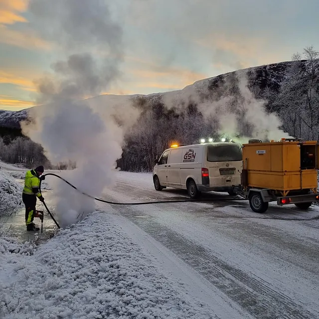 Arbeidsbil og maskin i vinterlandskap